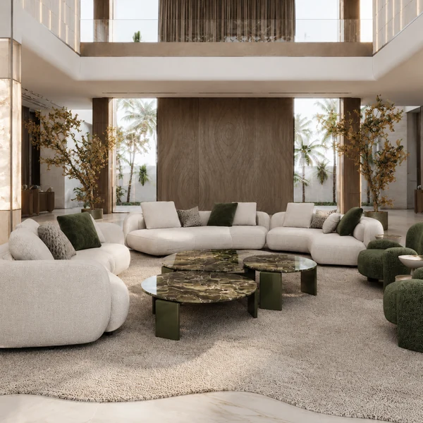 Living area with pale curved sofas, green lounge chairs and low tables.