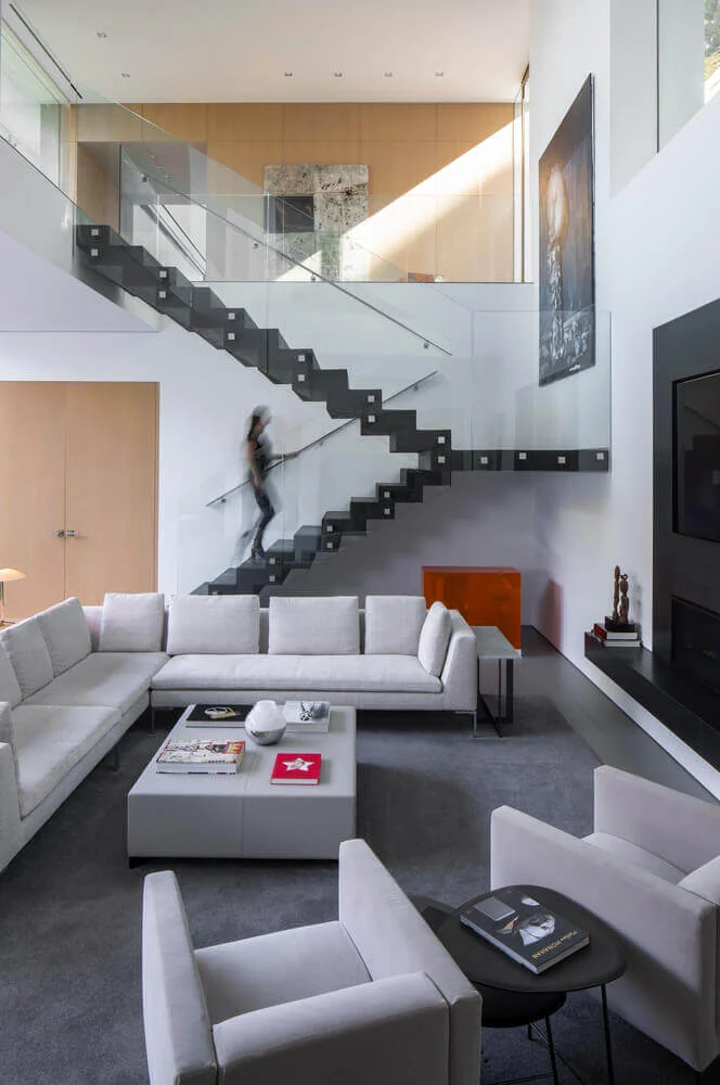 Double-height living room with sofas, armchairs and low tables