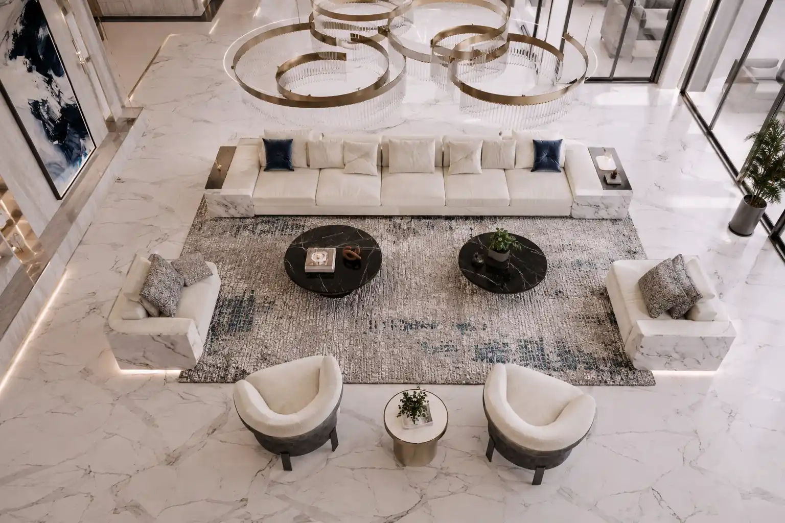 Living room with pale sofas, lounge chairs and dark round tables arranged around a central rug.