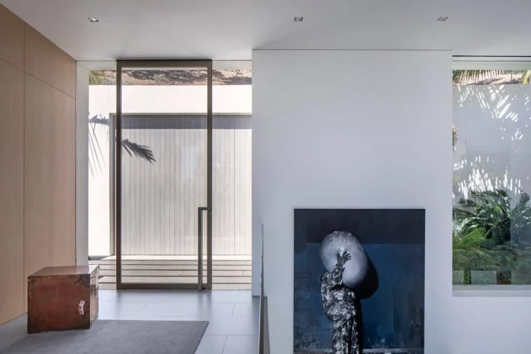 Minimal interior entry with a low cabinet, artwork and glazed opening